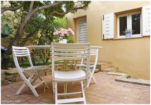 zwei weiße Stühle und ein Tisch und ein Fenster in der Unterkunft Paradiso Pool Apartments by DomusAway in Costa Paradiso + 32 Fotos