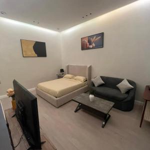 a living room with a bed and a couch and a television at الزعفران in Amman +3 photos