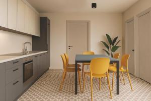 cocina con mesa de comedor y sillas amarillas en Central Guest, en Sauze d'Oulx