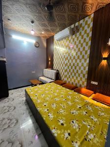a bedroom with a yellow bed with flowers on it at Mangal kripa homestay in Ujjain