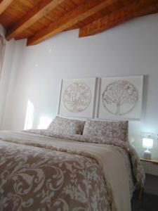 a bed in a bedroom with pictures on the wall at Apartamento en casco histórico Exclusivo con AC in San Martín de Valdeiglesias