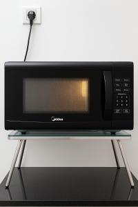 een magnetron op een standaard op een tafel bij Nice and Cosy RDA13A07B for 4 guests in Kuching +23 foto's