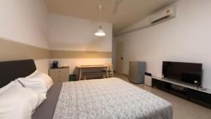 a bedroom with a bed and a flat screen tv at Cozy SK 1 Room 3 Pax UPM MRT in Seri Kembangan
