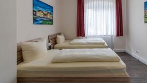 two beds in a room with a window at Hotel Schillerquartier in Kassel