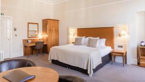 a hotel room with a large bed and a desk at The Bank in Anstruther