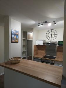 a kitchen with a counter and a clock on the wall at Orleans appartement 31 m2 in Saint-Jean-de-la-Ruelle