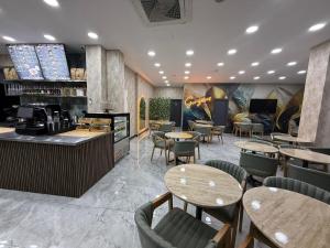 Un restaurante con mesas y sillas y un bar. en Dual Hotel Halkalı, en Estambul