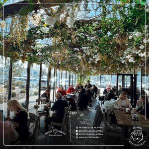 a group of people sitting at tables in a restaurant at White Home & Garden in Klaipėda
