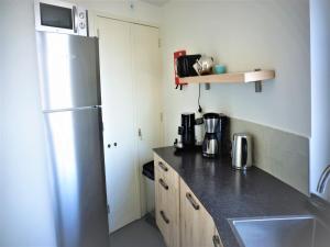 a kitchen with a stainless steel refrigerator and a sink at Renovated luxury water tower within walking distance of the beach boulevard in Vlissingen