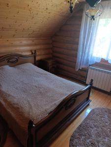 a bedroom with a bed in a log cabin at Біля Синевіру in Synevyrsʼka Polyana