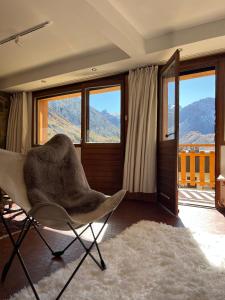 a living room with a chair and large windows at Tignes 2100 - Les Flocons - Vue panoramique in Tignes