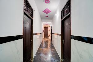 a hallway with two brown doors and a tile floor at Hotel O New Golden Moon in Meerut