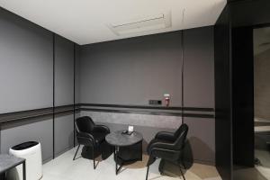 a waiting room with black chairs and a table at Hotel The Designers Premier Seongsu and Konkuk Univ in Seoul