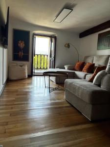 ein Wohnzimmer mit Sofa und Tisch in der Unterkunft Arbide, caserio tradicional vasco en Carranza in Karrantza