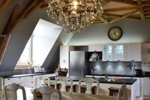 a kitchen with a dining table and a clock on the wall at Chateau De Jalesnes in Vernantes