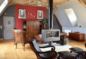 a living room with a wood stove and chairs at Chateau De Jalesnes in Vernantes