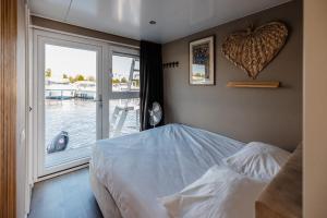 にあるFloating holiday home close to AMSのベッドと大きな窓のある寝室