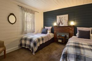 a bedroom with two beds and a mirror at Tuki Retreat in Smeaton