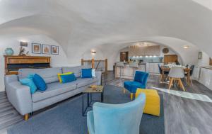 a living room with a couch and chairs and a kitchen at Maison à Tour Briançon in Briançon