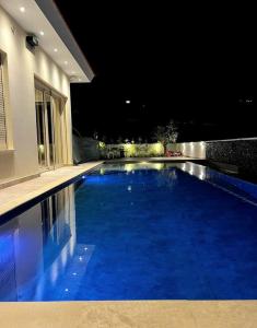 a large blue swimming pool in front of a house at Pareklisia Mystical Haven in Parekklisha