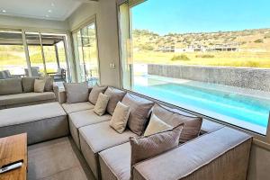 a living room with a couch and a swimming pool at Pareklisia Mystical Haven in Parekklisha
