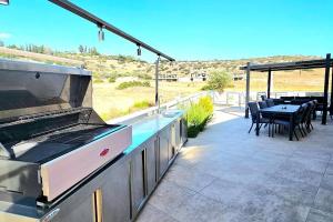 a patio with a grill and a table with chairs at Pareklisia Mystical Haven in Parekklisha