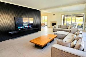 a living room with couches and a flat screen tv at Pareklisia Mystical Haven in Parekklisha