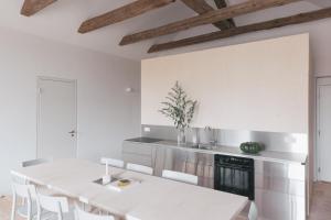 eine weiße Küche mit einem Tisch und Stühlen in der Unterkunft Verwalterinnenhaus in Werben + 121 Fotos