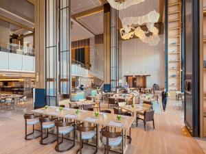 a restaurant with tables and chairs in a building at Pullman Yueyang in Yueyang