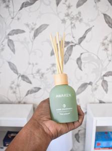 a hand holding a bottle of ayurvedic soap with bamboo sticks at Coffee Bean Home in Windhoek