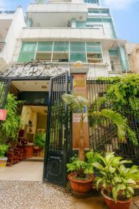 a gate in front of a building with potted plants at Hồng Lực Hotel HCM in Ho Chi Minh City