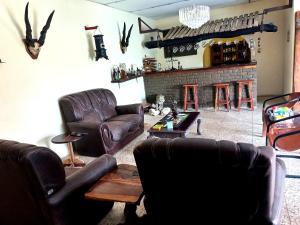 a living room with leather furniture and a fireplace at Bambi Lodge in Groutfontein