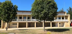 a building with a balcony and trees in front of it at Grand gîte en pleine nature in Domme