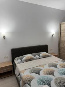 a bed with pillows on it in a bedroom at Apartament Giovanni in Giroc