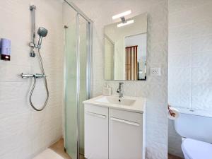 Ruelle-sur-TouvreにあるStudio cosy à 2 pas de l'Espace Caratのシャワーと洗面台を備えた白いバスルーム