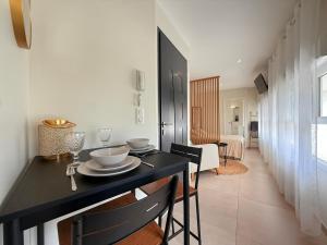 Ruelle-sur-TouvreにあるStudio cosy à 2 pas de l'Espace Caratの黒いテーブルと椅子のあるダイニングルーム