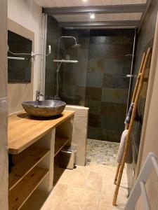 une salle de bain avec un lavabo en pierre et une douche dans l'établissement Mas Héritage, 1455 route de Balbiac, à Rosières