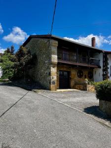 ein Steingebäude mit Balkon darüber in der Unterkunft Arbide, caserio tradicional vasco en Carranza in Karrantza