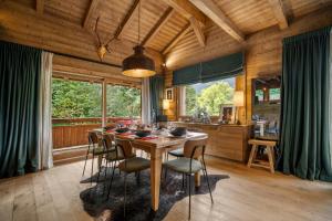 Un comedor de madera con mesa y sillas. en Luxury Chalet Black Mountain - 4BR, Sleeps 10, Fireplace, Mountain Views & Garden - Megève, en Megève
