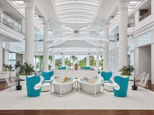 un hall avec des chaises bleues et blanches dans un bâtiment dans l'établissement Mövenpick Hotel Mactan Island Cebu, à Mactan
