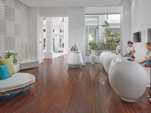 two children sitting in a living room with white furniture at Mövenpick Hotel Mactan Island Cebu in Mactan