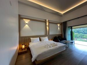 a bedroom with a large white bed with a large window at PASSA ผัสสะ Tea Plantation @Mae On in Ban Huai Kaeo