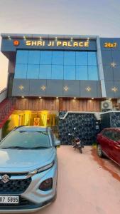 a car parked in a parking lot in front of a building at Hotel shree ji palace in Pāldhi