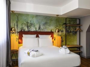 ein Schlafzimmer mit einem Bett mit zwei Handtüchern darauf in der Unterkunft Mercure Saint Omer Centre Gare in Saint-Omer + 93 Fotos