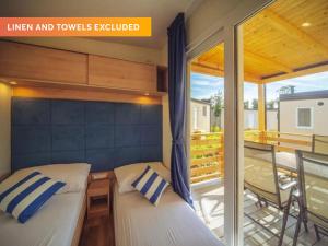 two beds in a tiny house with a balcony at Camping Park Umag - Roan in Umag +33 photos