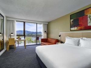 ロックハンプトンにあるMercure Rockhamptonの大きなベッドと机があるホテルの部屋