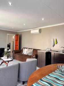 a living room with a couch and a table at Marjaniek Wedding Venue & Guest House in Rietfontein