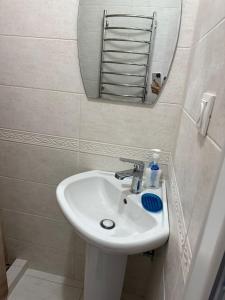 a bathroom with a white sink and a mirror at Домик в общем дворе с хозяином in Komrat
