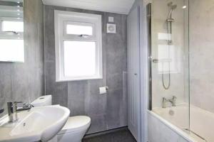 ミルフォード・オン・シーにある4 Bedroom Superior Lodge with Hot Tubの洗面台、トイレ、浴槽を備えたバスルーム +3枚の写真