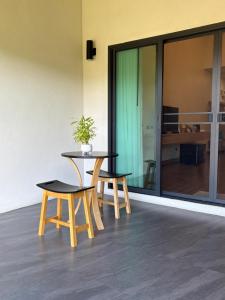 a table and two chairs with a potted plant on it at PASSA ผัสสะ Tea Plantation @Mae On in Ban Huai Kaeo